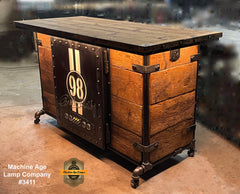 A large industrial-style bar made of barn wood with a hidden fridge and a Carroll Shelby door front, featuring LED lighting and stewert Warner gauges.